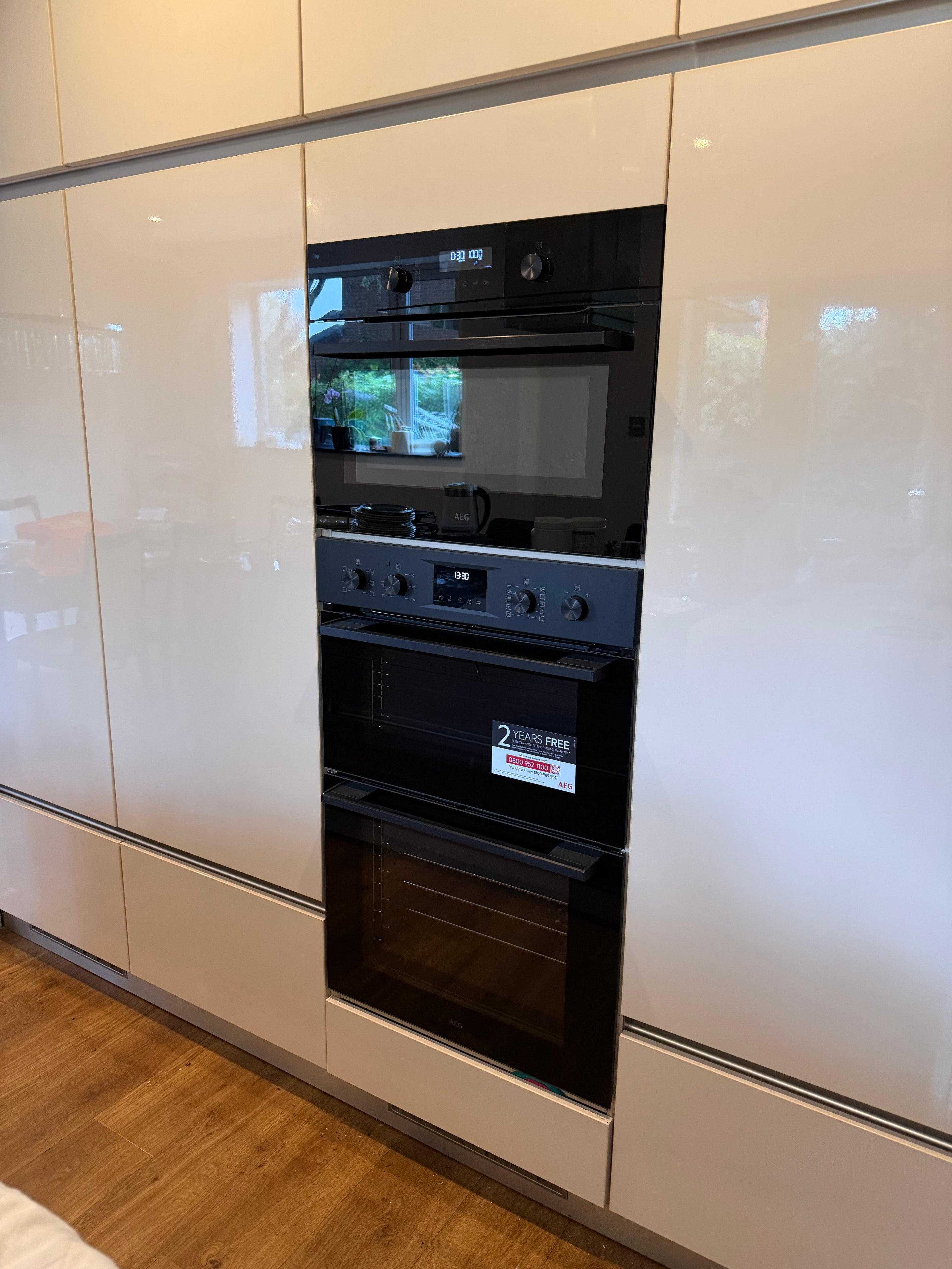 AEG oven and microwave tower installation in cream gloss cabinetry